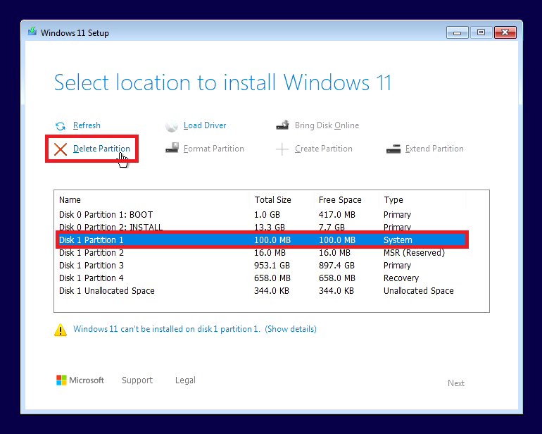 Windows 11 Setup drive selection screen showing existing partitions from a previous installation with the Delete Partition option